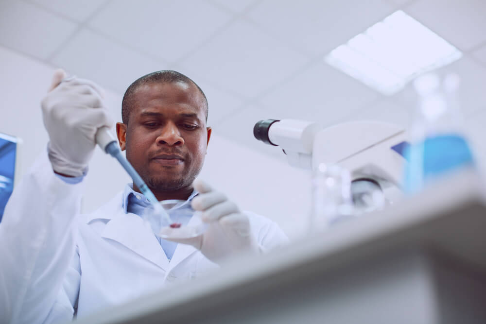 Serious Skilled Scientist Conducting a Blood Test and Wearing a Uniform