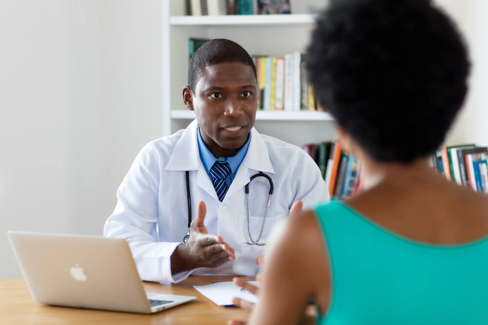 African American Doctor Talking  With Patient at Hospital