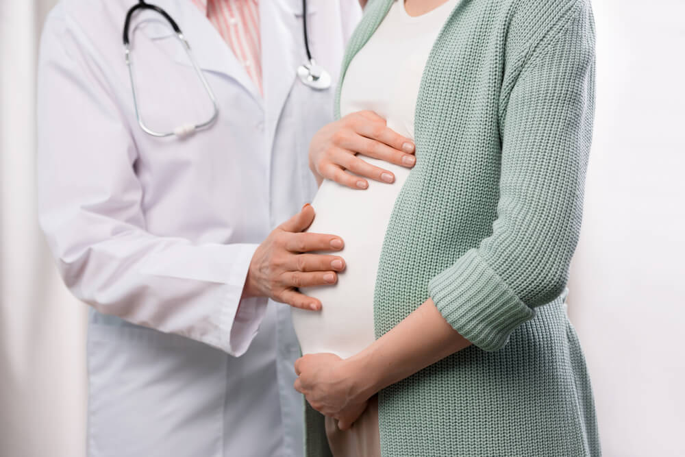 Cropped Shot of Doctor Examining Pregnant Woman During Medical Consultation