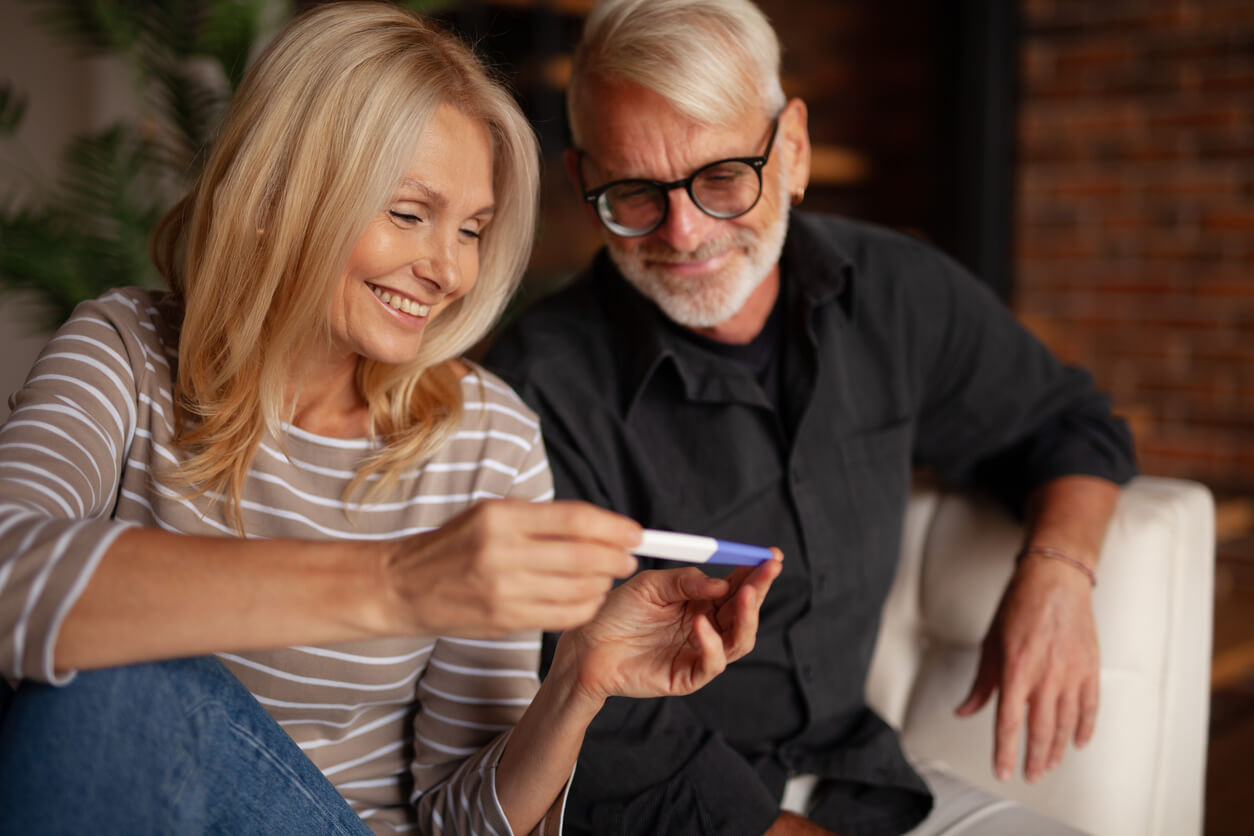 Mature Parents With a Pregnancy Test in Their Hands Are Sitting at Home