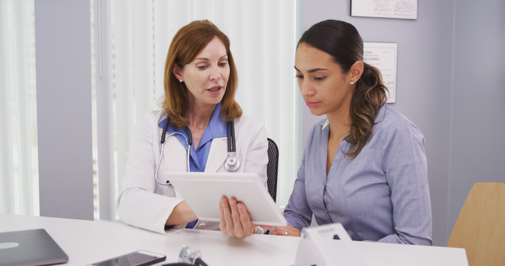 Portrait of Beautiful Latina Patient Consulting With Doctor on Tablet