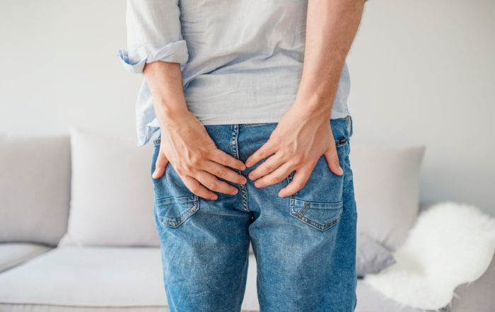 Man With Hemorrhoids Holding His Butt in Pain.