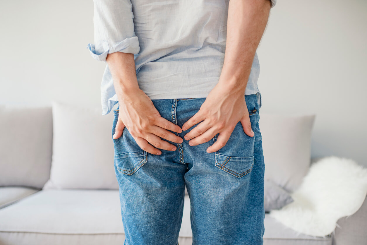 Man With Hemorrhoids Holding His Butt in Pain.
