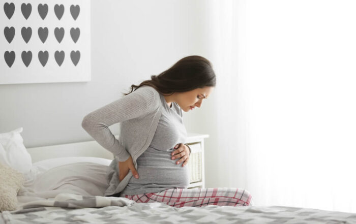 Pregnant Woman Suffering From Pain in Bedroom