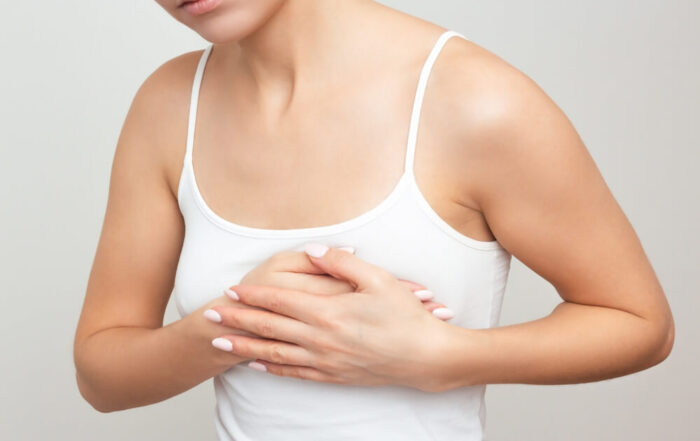 Young Woman in White Underwear Has Folded Her Arms on Her Chest, Is Experiencing a Sharp Severe Pain in the Heart Area