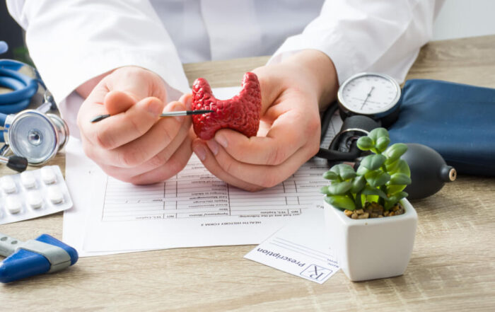 At Doctors Appointment Physician Shows To Patient Shape Of Thyroid Gland With Focus On Hand With Organ