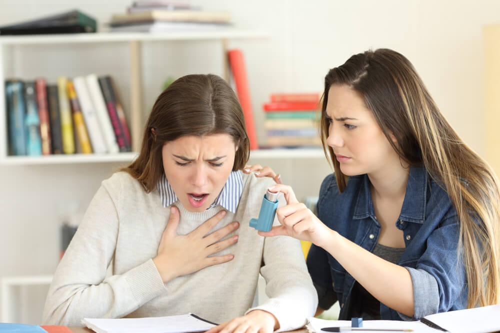 Student Helping Her Asmathic Friend Giving the Inhaler During an Asthma Attack