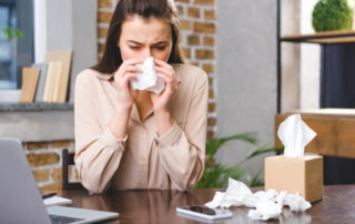 Young Businesswoman Suffering From Allergy at Workplace