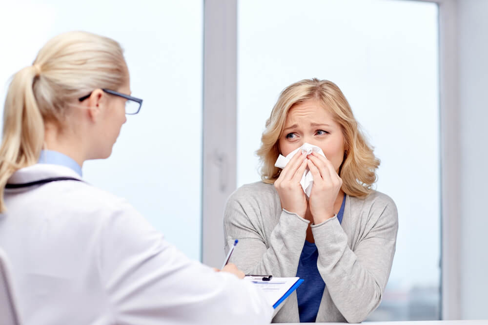 Doctor and Ill Woman Patient With Flu at Clinic