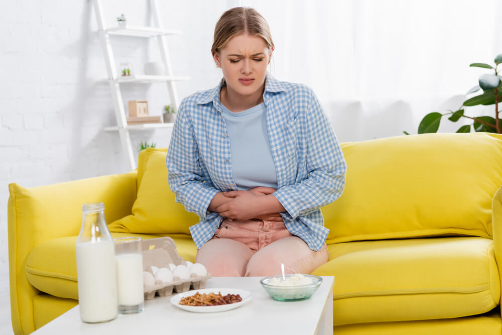 Tired Woman With Allergy Looking at Food on Table