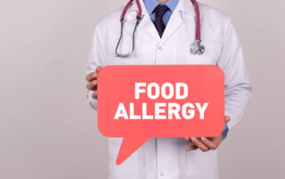 Doctor Holding Speech Bubble With Food Allergy Message