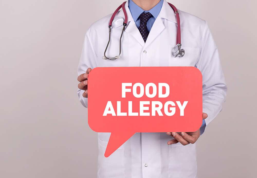 Doctor Holding Speech Bubble With Food Allergy Message