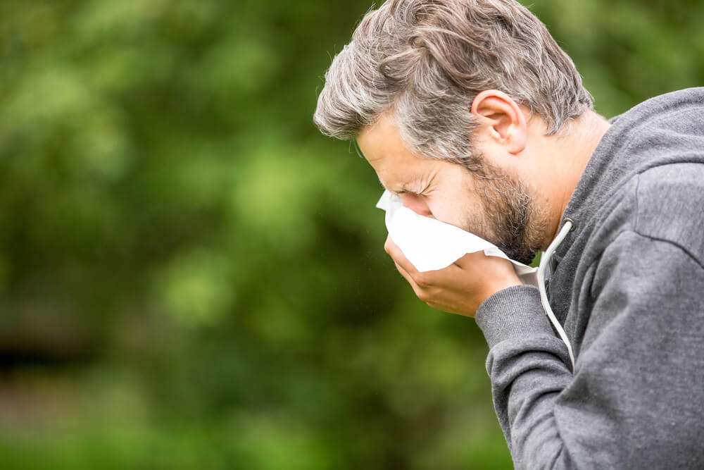 Man with allergy or an infection sneezing