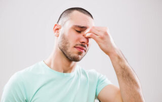 Portrait of young man who is having pain in his sinus