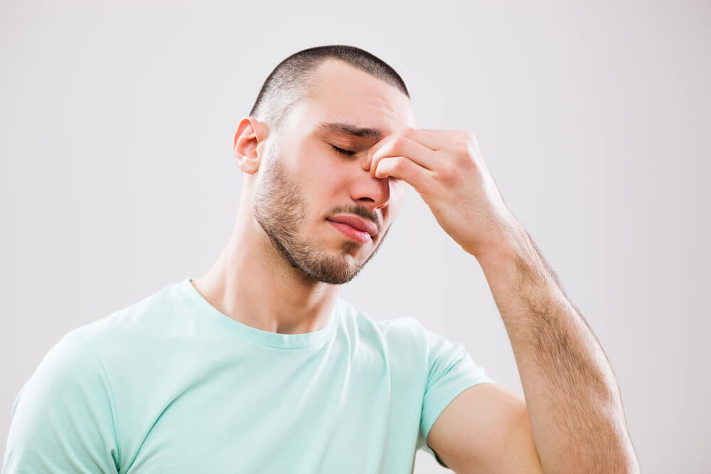 Portrait of young man who is having pain in his sinus