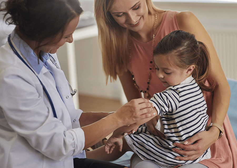 Mother Holding Her Daughter While the Doctor is Administering Her a Vaccine