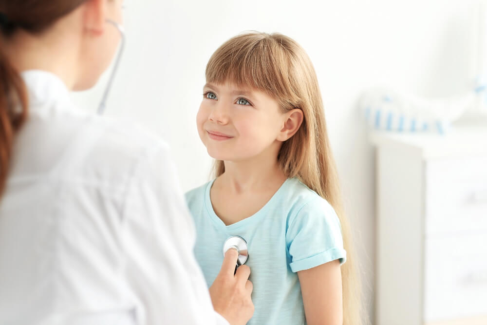 Pediatrician Checking A Young Smiling Girl