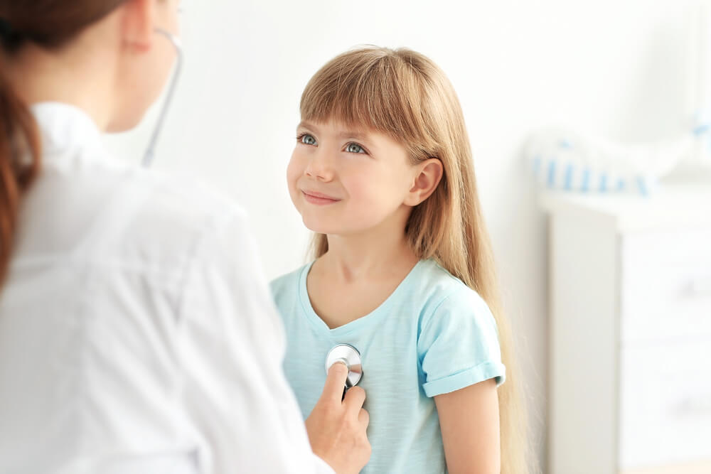 The Importance of Well-Child Checks Pediatrician Checking A Young Smiling Girl