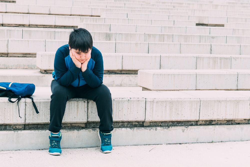 Boy Sitting on a Ladder With Sad Look