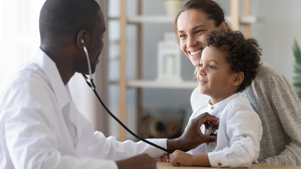 Doctor Examining Baby Boy While His Mother Holds Him