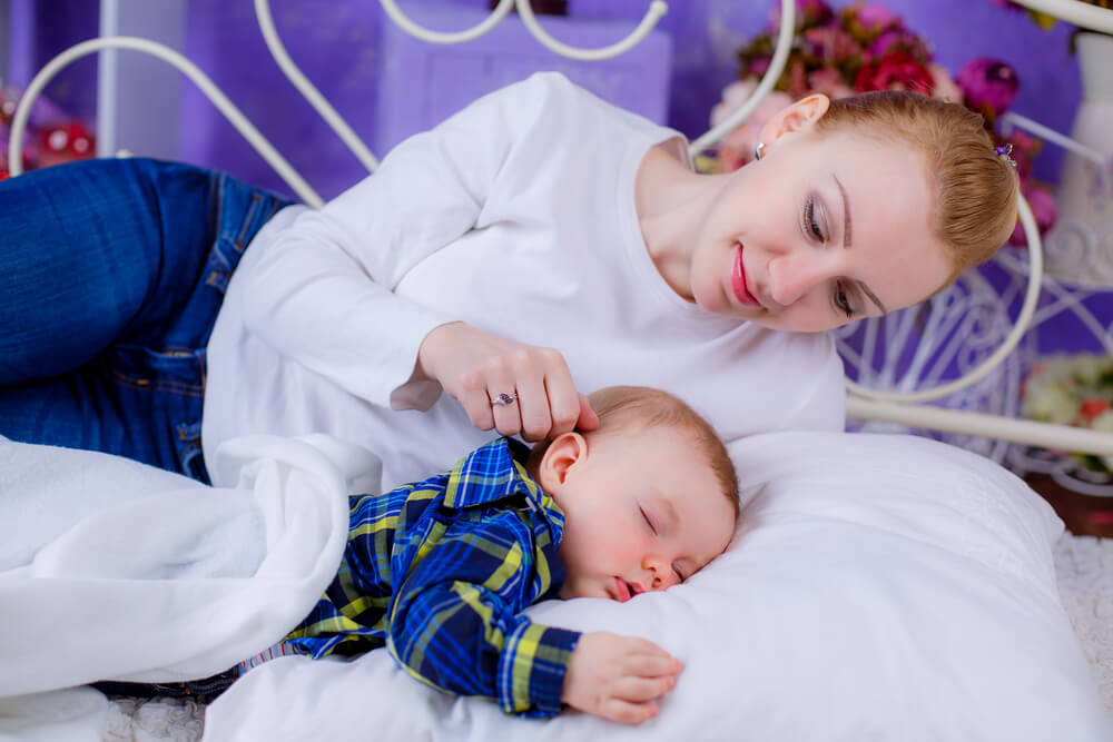 Young Beautiful Mother Putting Her Newborn Baby