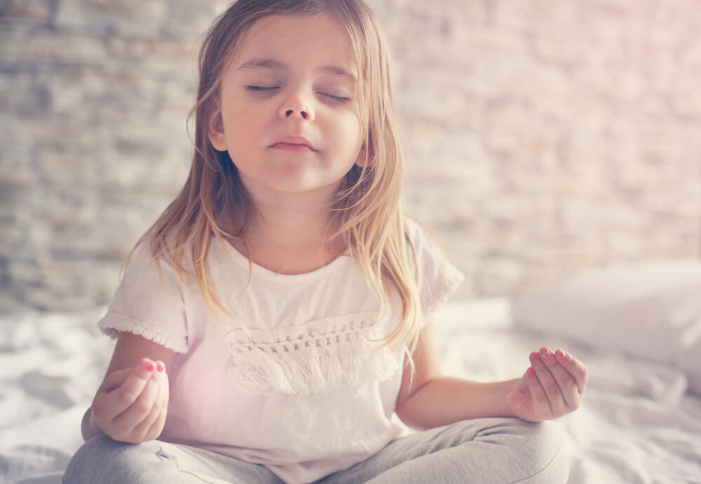 Little Girl Doing Yoga in Bed.