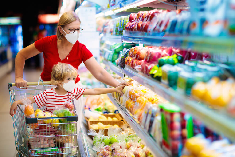 Mother and Child Wearing Surgical Face Mask Buying Fruit in Supermarket