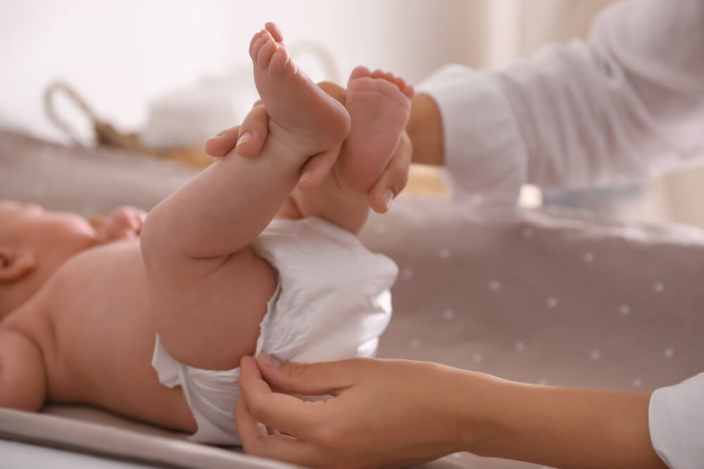 Mother Changing Her Baby’s Diaper on Table