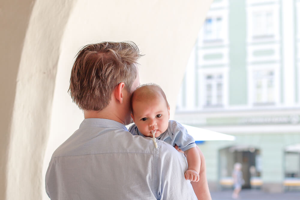 Newborn Boy Vomiting While His Dad Carrying Him on Outdoor Background. 