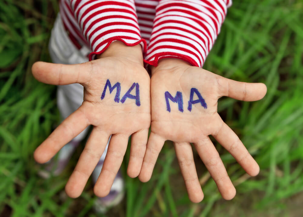 The Word Mom Written in Children’s Hands