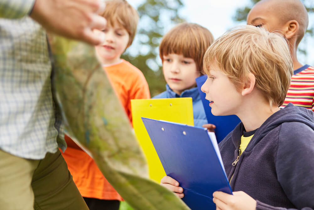Curious Kids With Clipboard Play Treasure Hunt or a Game of Nature in Nature