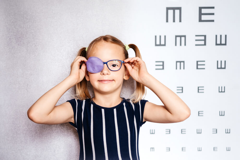 Happy Little Girl Wearing Glasses and Eye Patch or Occluder, Amblyopia (Lazy Eye) Treatment