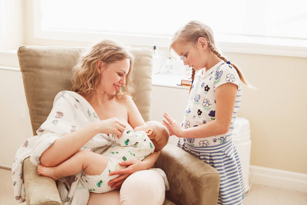 Group Portrait of White Caucasian Family of Three, Mother Breastfeeding Newborn Baby