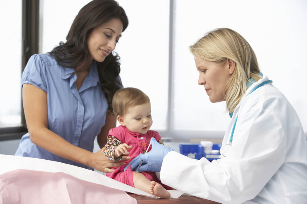 Doctor In Surgery Giving Baby Girl Injection