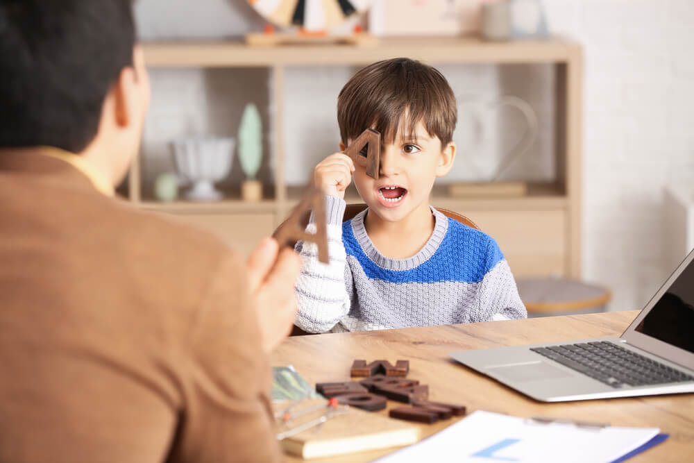 Cute Little Boy Training Pronounce Letters at Speech Therapist Office