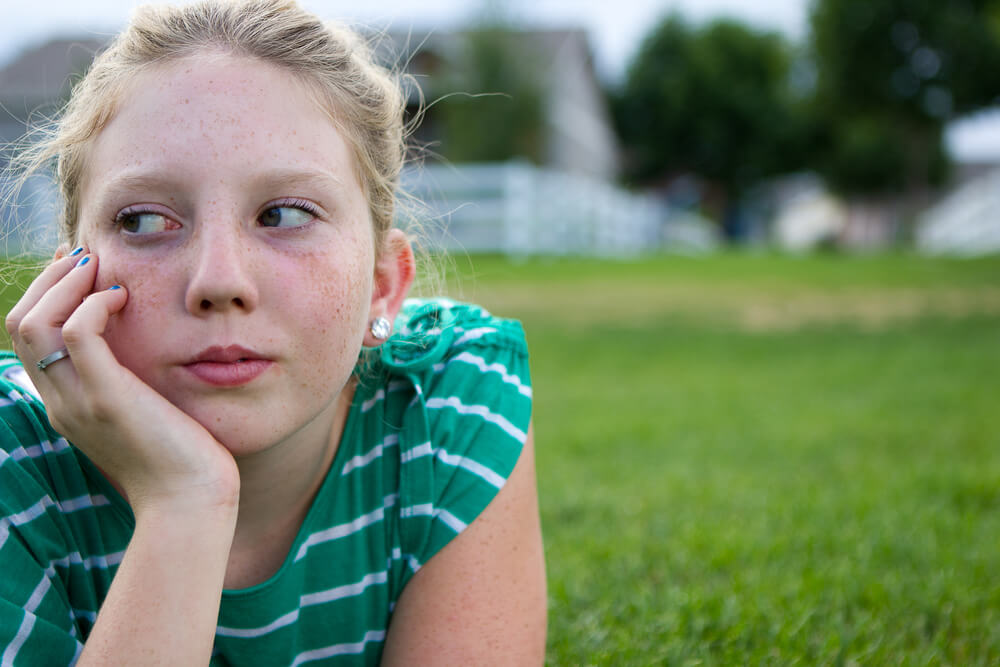 Young Adolescent Girl Looking Bored at a Park.