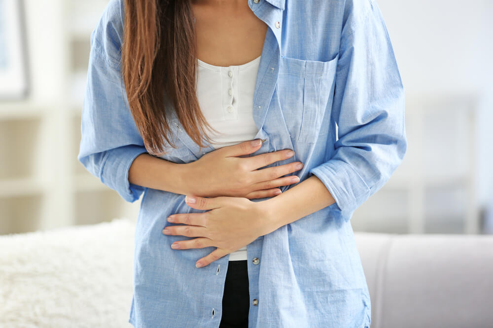 Young Woman Suffering From Abdominal Pain at Home