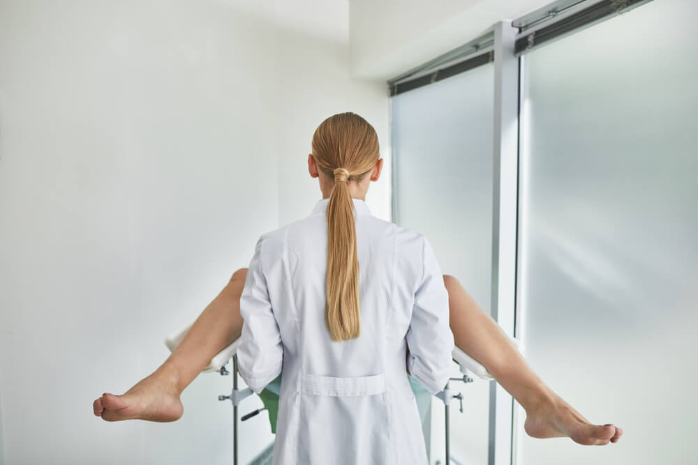 Back View Portrait of Female Gynecologist During Pelvic Exam