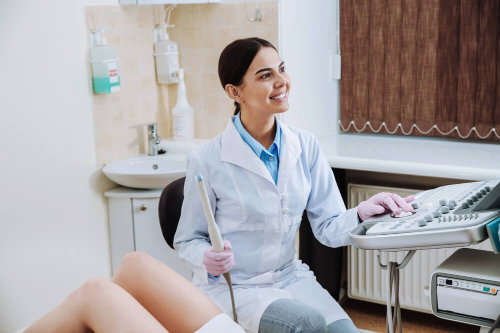 Female Doctor Conducting Ultrasound Examination of Woman in Clinic