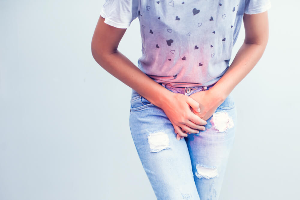 Young Woman With Hands Pressing Her Lower Abdomen