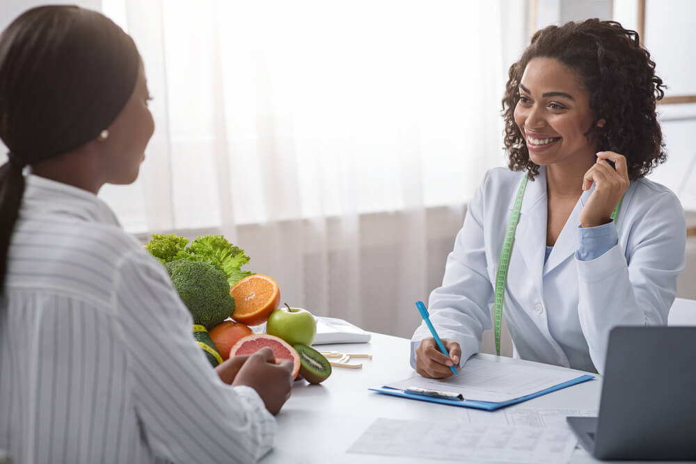 Woman Nutritionist Talking to Female Patient and Taking Notes