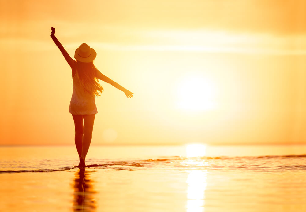Lady’s Silhouette With Raised Arms Against Calm Sunset Beach