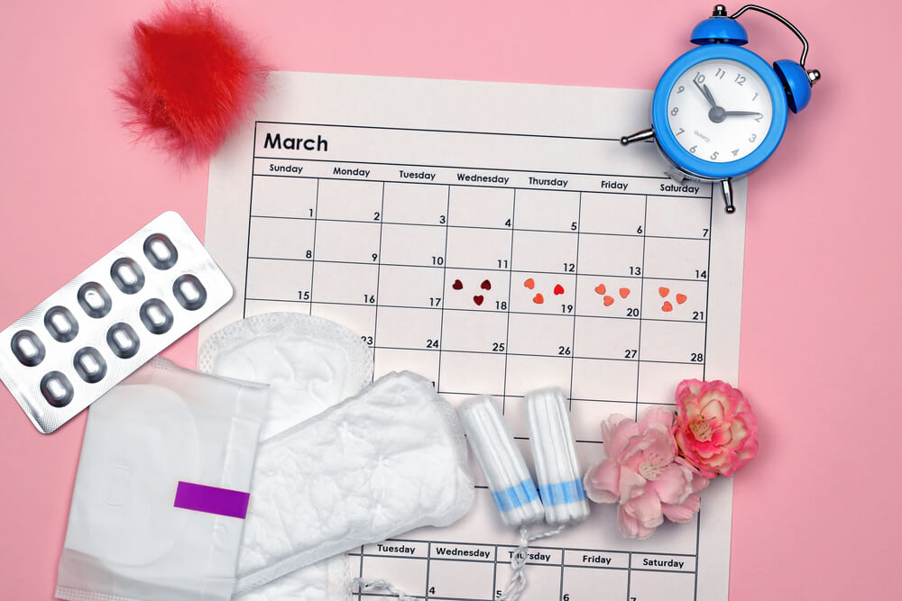 Menstrual Pads and Tampons by the Period of the Menstrual Cycle on a Pink Background