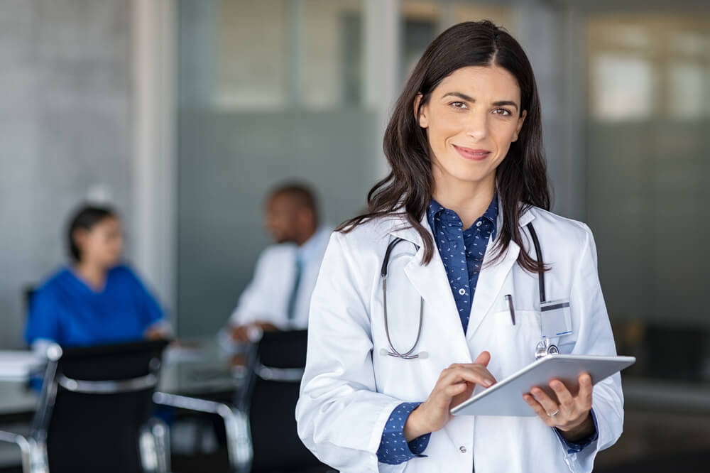 Portrait of Beautiful Mature Woman Doctor Holding Digital Tablet and Looking at Camera