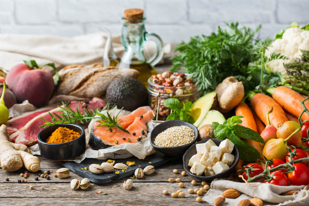 Assortment of healthy food ingredients for cooking on a wooden kitchen table.