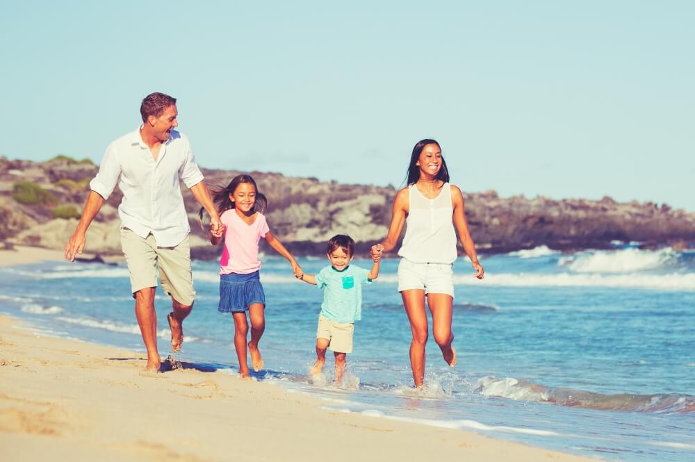 Young Happy Family Having Fun on the Beach Outdoors