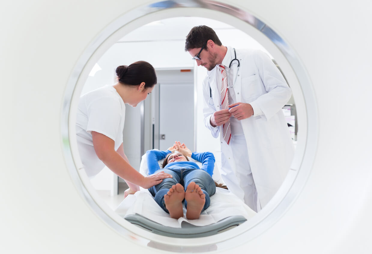 Doctor, Nurse, and Patient at CT Scan Tomography in Hospital, Shot Through the Tube of Device