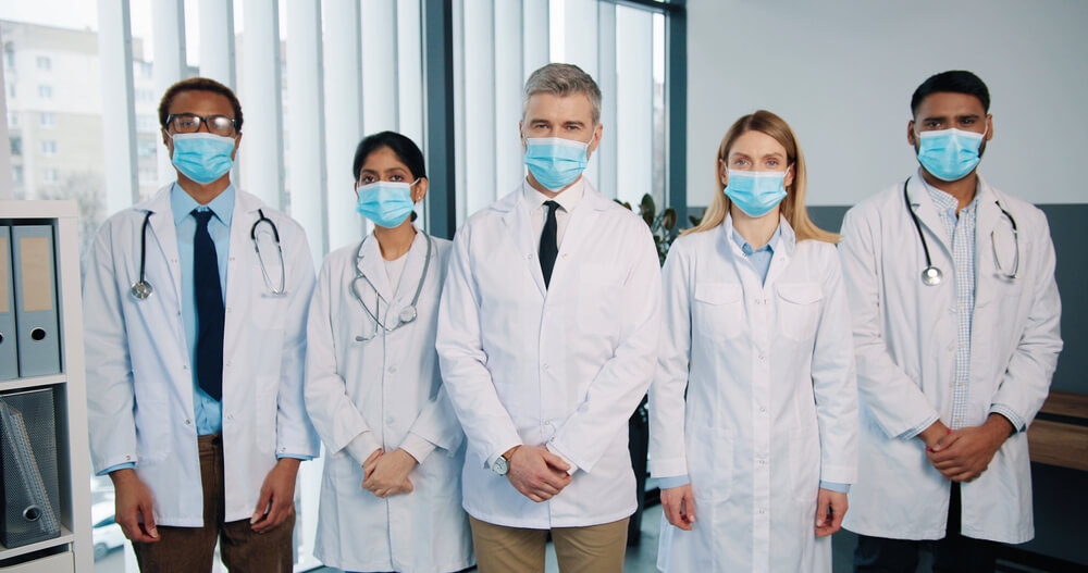Doctors and Physicians in Medical Masks Standing in Hospital