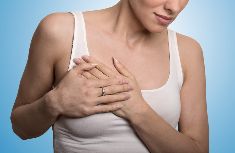 Young Woman With Breast Pain Touching Chest Colored Isolated On Blue Background