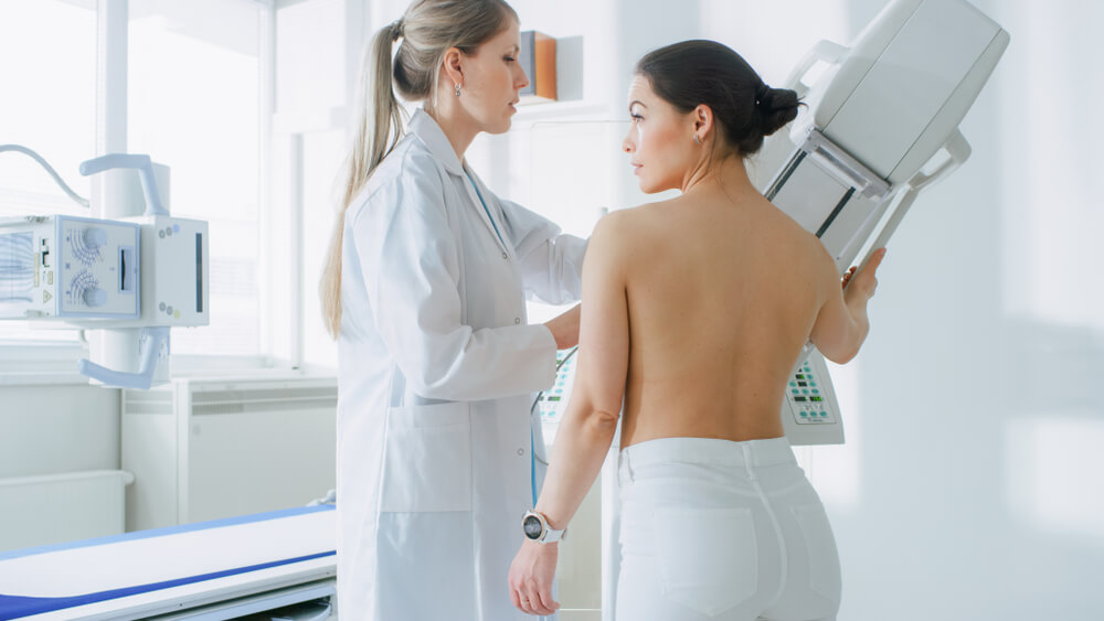 Doctor Adjusts Mammogram Machine for a Female Patient